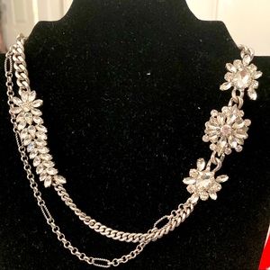 Neck less in silver tones with white glass stones.